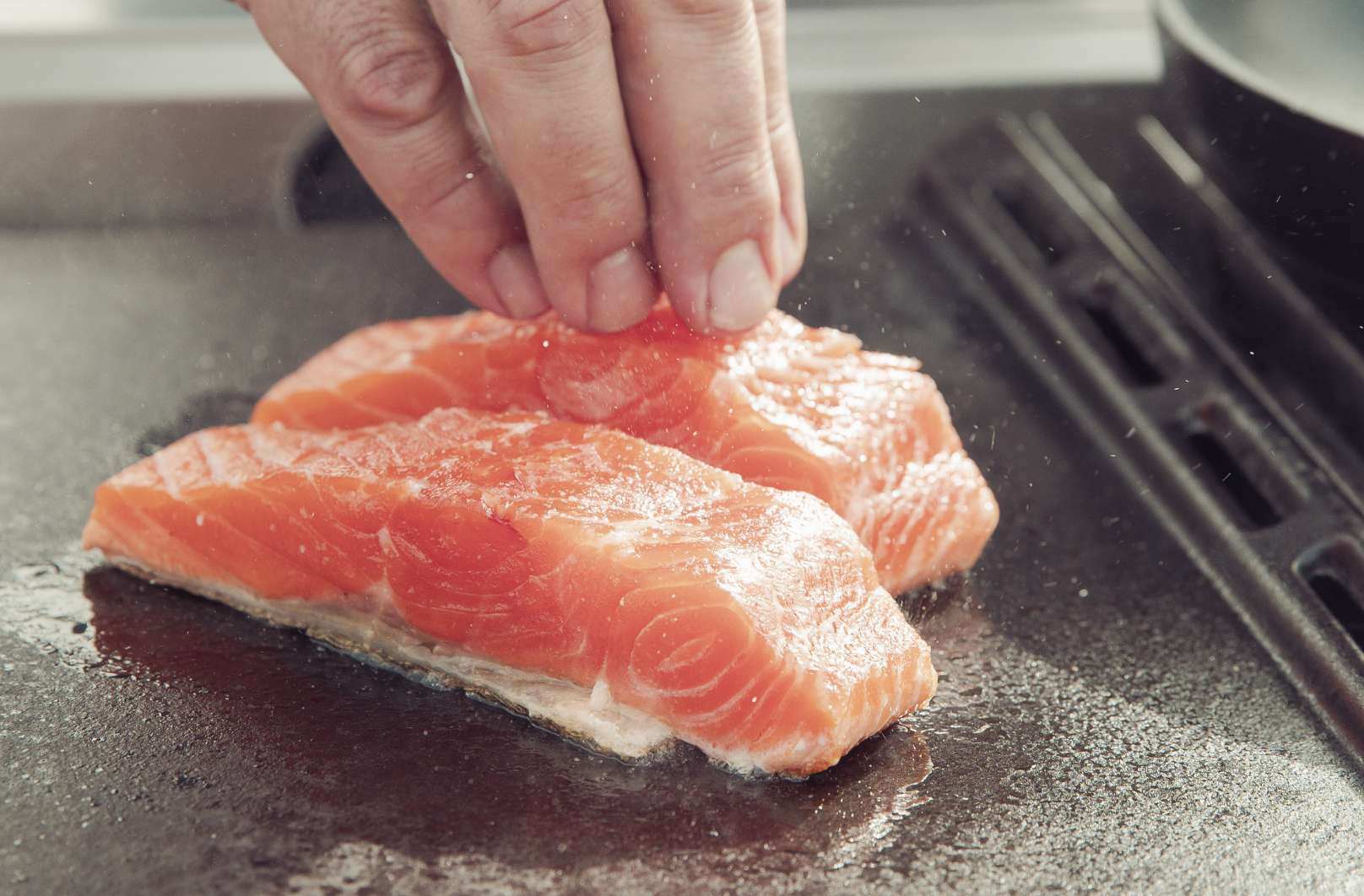 Lachs wird in Öl gebraten auf einer Plancha