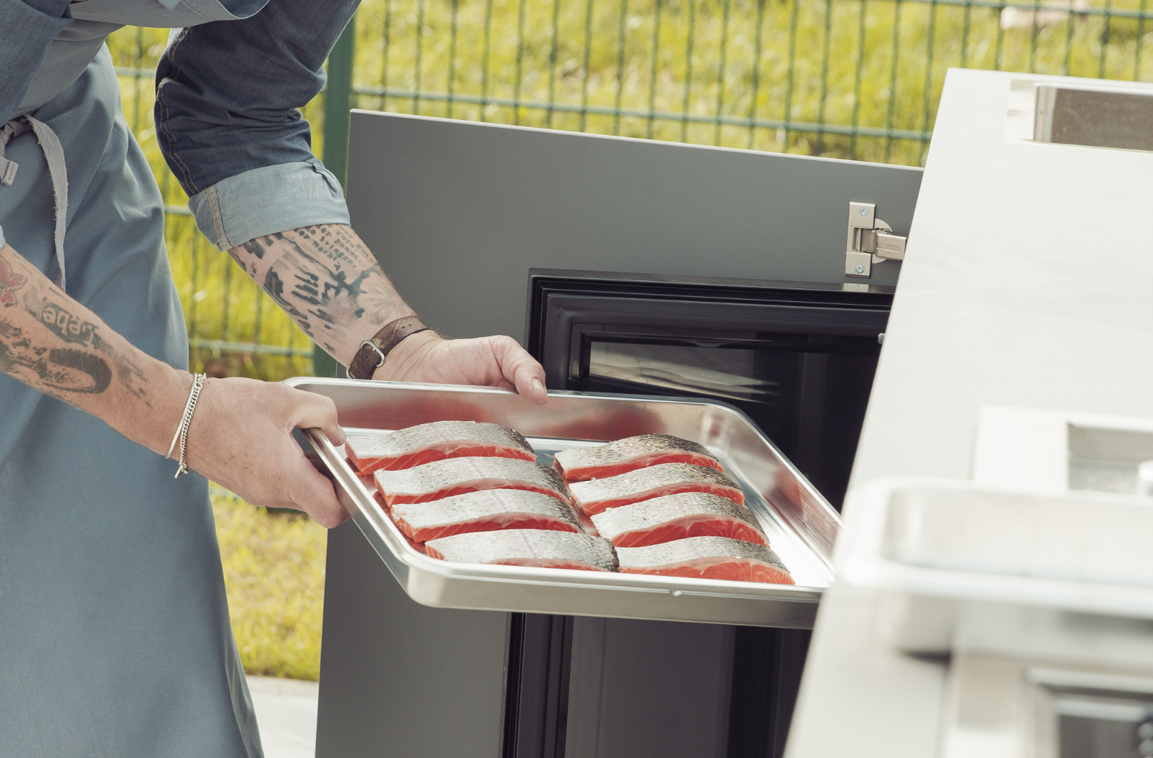 Lachs wird in einen Outdoor Kühlschrank zum Kühlen gelegt  maet black