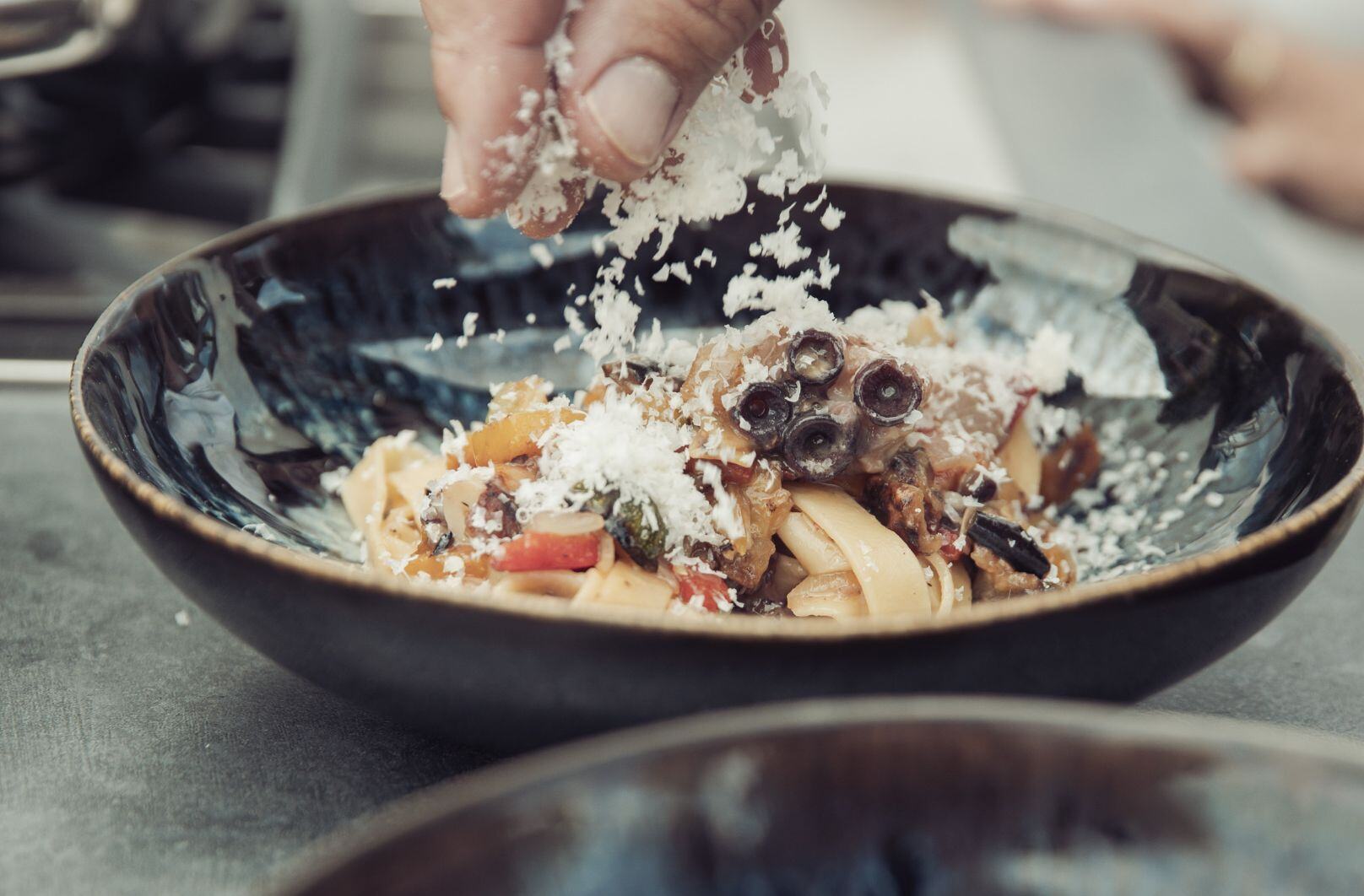 maet black - Pasta mit Pulpo und Gemüse dekorieren mit Käse