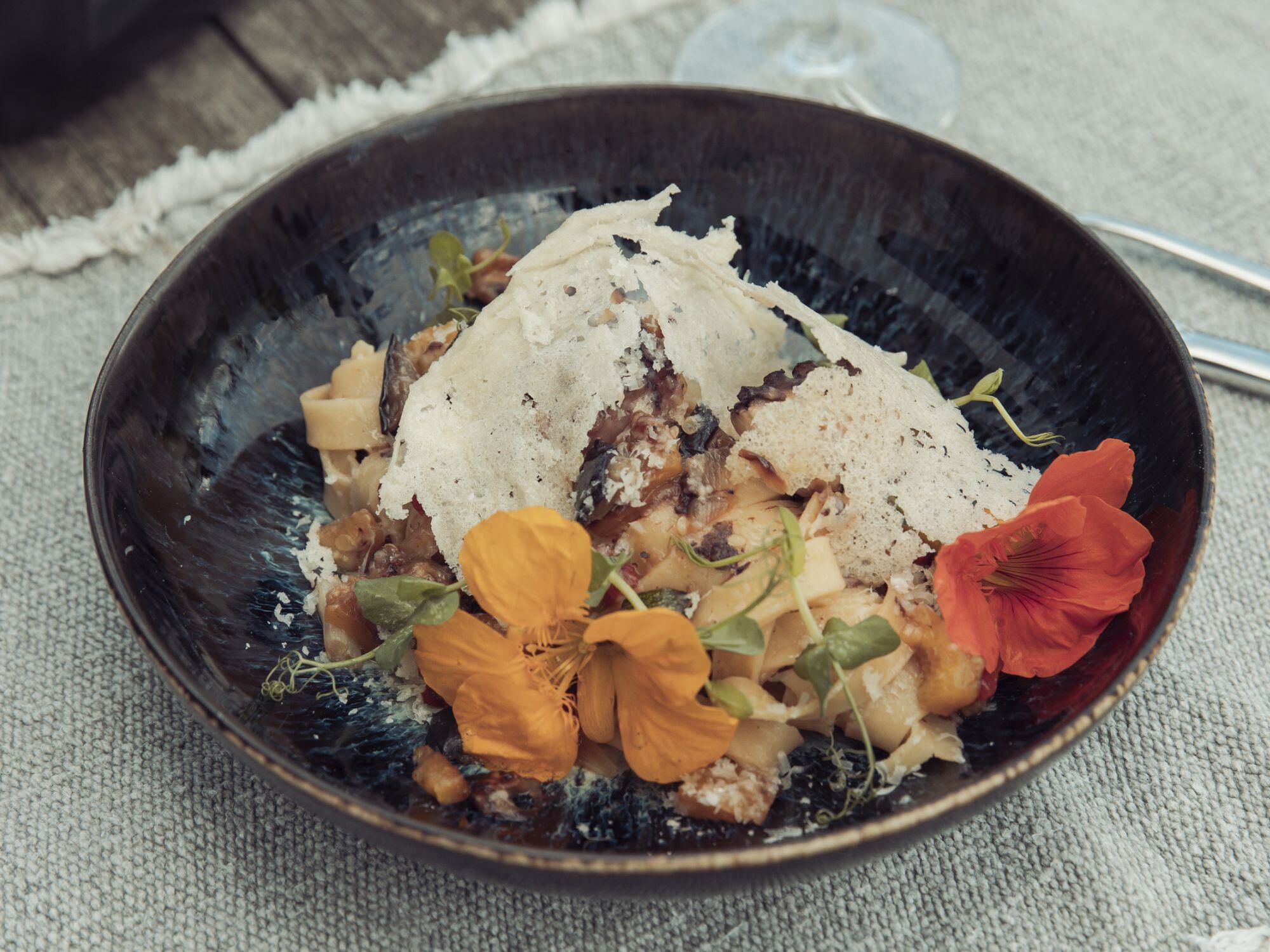 maet black - Pasta mit Pulpo und Gemüse dekoriert mit Grana Padano und Blumen